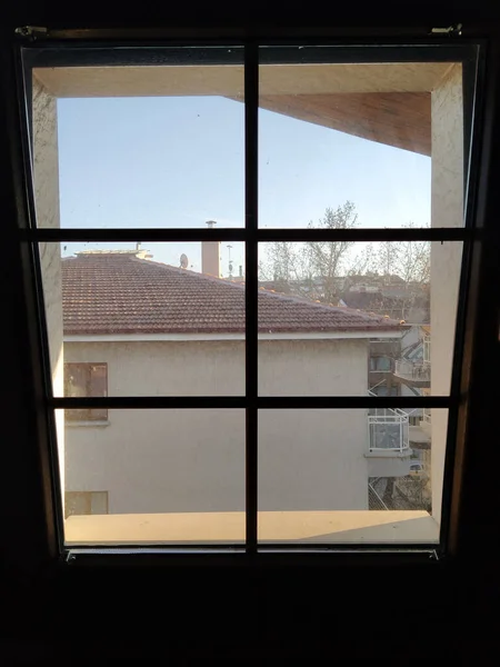 Yandaki evin penceresinden ev manzarası, mavi gökyüzü.