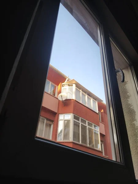 Pencereden bir apartman, mavi gökyüzü.