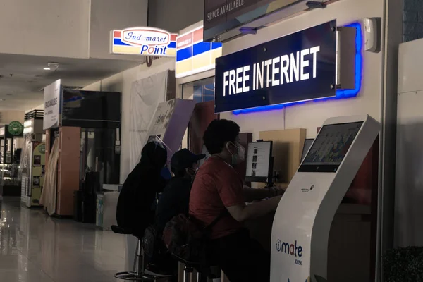 Pekanbaru, Endonezya - 20 Haziran 2021: Bir grup insan havaalanındaki ücretsiz internet tesislerini kullanıyor