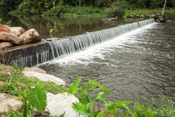 Small waterfall from brown river