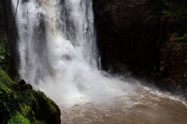 Yağmur mevsiminde yağmur yağdıktan sonra tropikal yağmur ormanları içindeki büyük kaya şelalesi göletine güçlü bir akarsu akıntısı..