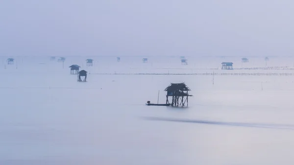Nebeldecke violettes Meer und schwimmendes Haus — Stockfoto