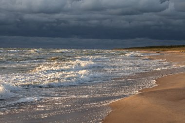Günbatımı ve fırtına öncesi sessizlik plaj üzerinde koyu mavi gökyüzü