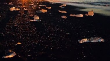 Jokulsarlon Haliç yanındaki siyah volkanik kum plajı üzerinde küçük buzdağları