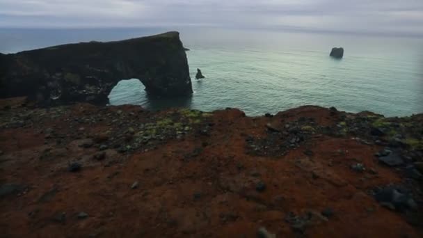 Dyrholaey, un arco marino volcánico negro . — Vídeos de Stock