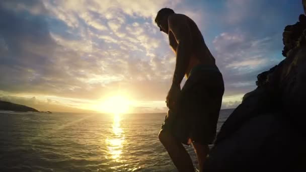 Acantilado saltando frente voltear en el océano al atardecer — Vídeos de Stock