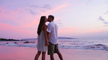 Genç bir çift sahilde yürüyor.