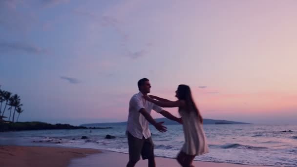 Νεαρό ζευγάρι παιχνιδιάρικα στην παραλία — Αρχείο Βίντεο