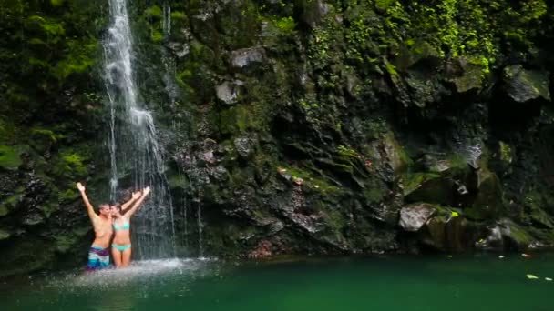 Pareja de pie bajo la cascada — Vídeos de Stock