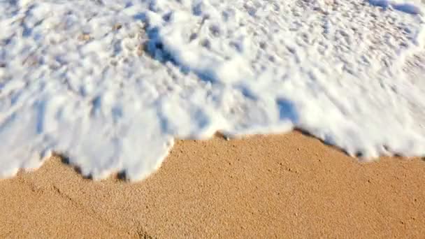 Feche acima das ondas que rolam acima da praia arenosa branca. — Vídeo de Stock