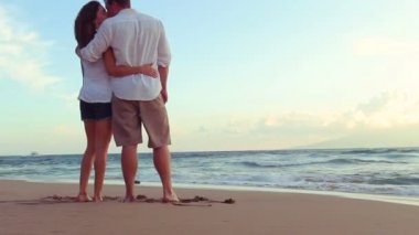 Güzel genç çift Beach günbatımında öpüşme