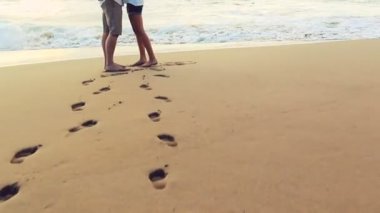 Güzel genç çift Beach günbatımında elele