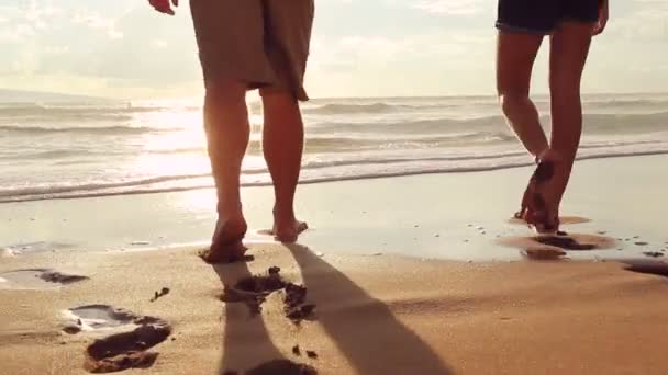 Beau jeune couple marchant sur la plage tenant les mains au coucher du soleil — Video