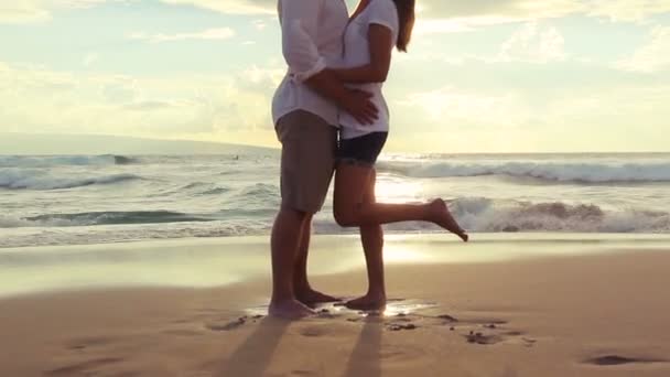 Szenvedélyes pár szerelmes a tengerparton naplementekor — Stock videók