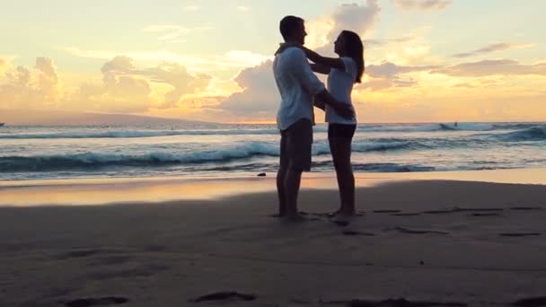 leidenschaftliches verliebtes Paar bei Sonnenuntergang am Strand. Frau springt Mann in die Arme