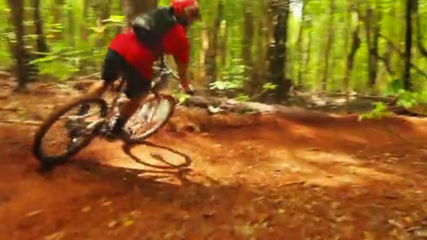 Intens mountainbiken Volg cam shot rond steile vuil berm gaat snel. Young fit man berijdt mountainbike. — Stockvideo