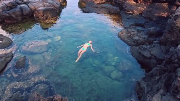 Vacker kvinna flyter i Tide pool vid solnedgången. — Stockvideo