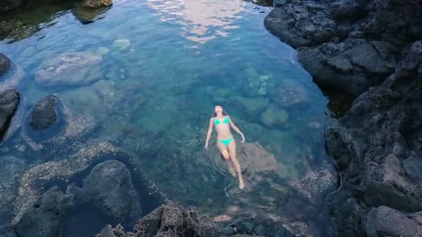 Belle femme flottant sur le dos dans la piscine à marée. Détente dans la nature . — Video