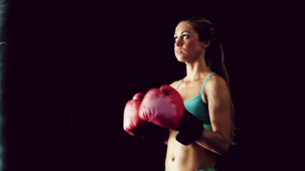 Hermosa joven atleta Ejercicio para la defensa personal con guantes de boxeo y bolsa de cuerpo . — Vídeos de Stock