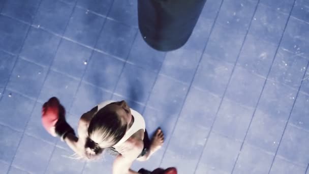 Young Strong Female Athlete Punching Body Bag Shot From Above Looking Down. Self Defense Training. — Stock Footage Young Strong Female Athlete Punching Body Bag Shot From Above Looking Down. Self Defense Training. Stock Footage
