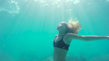 Güzel güneş fişekleri yavaş hareket ile yüzeye doğru sualtı Yüzme kadın