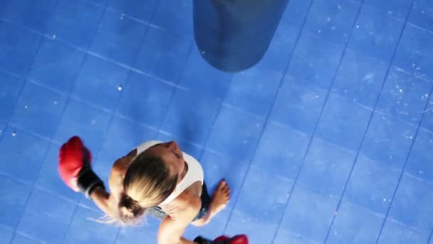 Giovane forte atleta donna sacco da boxe corpo abbattuto dall'alto guardando giù. Formazione di autodifesa . — Video Stock