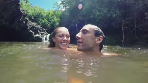 Ein Selfie-Paar küsst sich. Saftig grüner Wasserfallteich — Stockvideo
