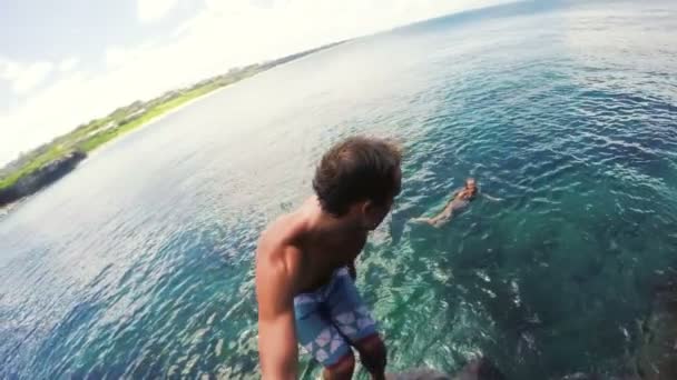 Tylnej klapki Selfie Stick Slow Motion Gopro Pov młody człowiek skoki z urwiska do oceanu na Hawajach. — Wideo stockowe