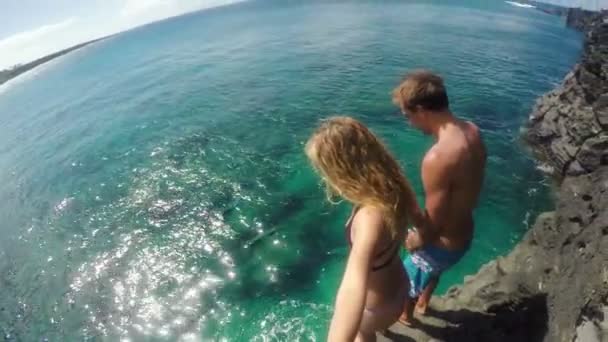 GoPro Pov lassított fiatal vonzó pár ugrás szikláról az óceánba. Fun nyár életmód. Selfie Stick.