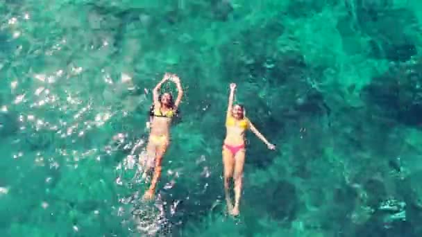 Belles femmes en bikinis flottant dans l'océan bleu cristal. Style de vie de vacances de luxe . — Video