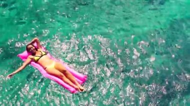 Güzel genç etnik Pasifik Adalı kadında şişme bota pembe: Hawaii kristal okyanusta yüzen Bikini.