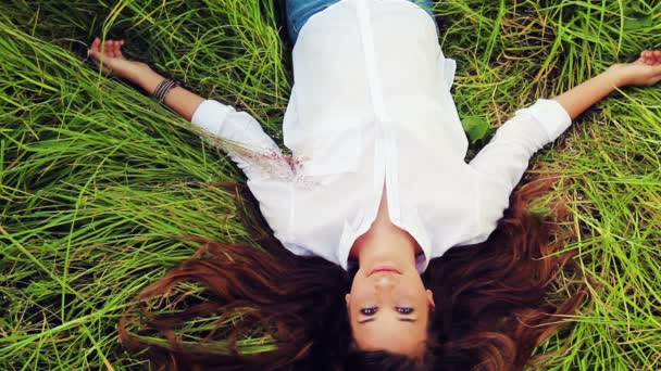 Beautiful Girl Lying on the Meadow and Dreaming. Enjoy Nature. Blinks Open Eyes and Smiles — Stock Video