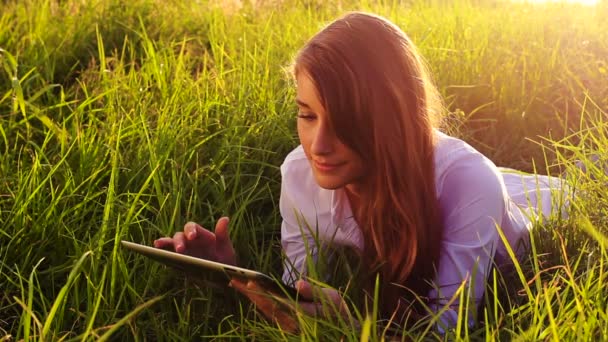 Giovane donna utilizzando Tablet Computer Touchscreen. Bella luce del tramonto all'aperto in natura . — Video Stock