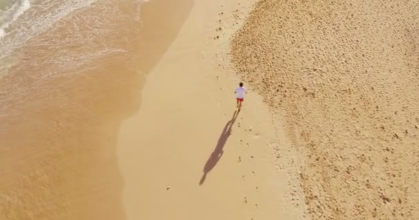 4K Aerial Running runner man atleta treinando ao ar livre exercitando na praia ao nascer do sol — Vídeo de Stock