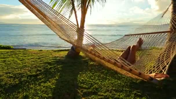 Mujer joven hermosa que relaja en hamaca tropical al atardecer . — Vídeos de Stock