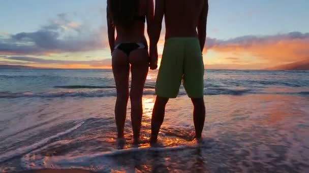 Feliz pareja romántica joven caminando en la playa disfrutando de la puesta de sol — Vídeos de Stock