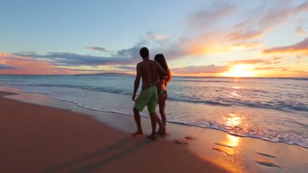 Feliz pareja romántica joven caminando en la playa disfrutando de la puesta de sol — Vídeos de Stock