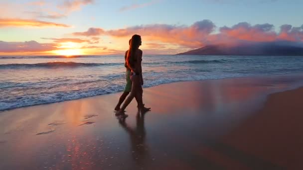 Feliz pareja romántica joven caminando en la playa disfrutando de la puesta de sol — Vídeos de Stock