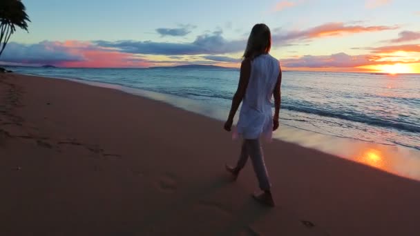 Glückliche reife Frau genießt einen Sonnenuntergangsspaziergang am Strand. — Stockvideo