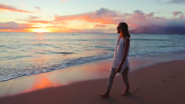 Šťastný zralá žena se těší na západ slunce chodit na pláži. — Stock video