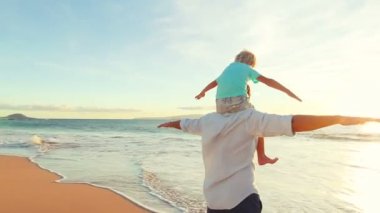 Baba ve oğul uçak birlikte sahilde günbatımı oynama..