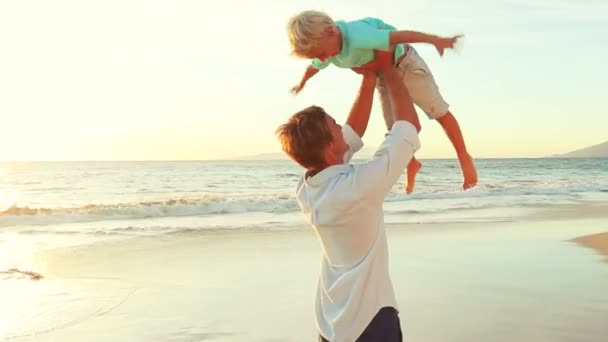 Padre e hijo jugando juntos en la playa al atardecer . — Vídeo de stock