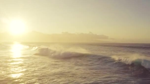 Ondas aéreas sobre el océano rompiendo la luz del atardecer — Vídeo de stock