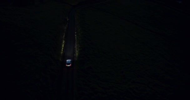 4k Auto fahren in der Nacht auf kurvenreicher Landstraße in den Hügeln. Luftaufnahme. Scheinwerfer. — Stockvideo