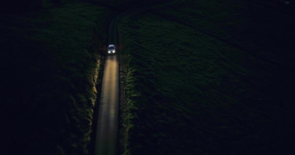 車のヘッドライトは、夜間の暗闇の中で運転。上から空中ショット — ストック動画