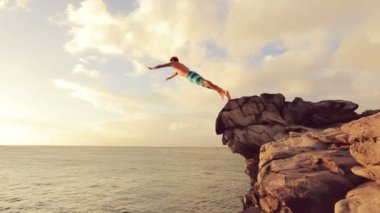 Gün batımında Jumping Cliff. Açık hava yaşam tarzı atlama uçurum yaz Ekstrem Sporlar