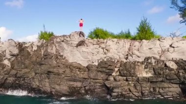Aşırı Cliff Backflip atlama. Havadan görünümü Cliff mavi okyanus içine atlama.