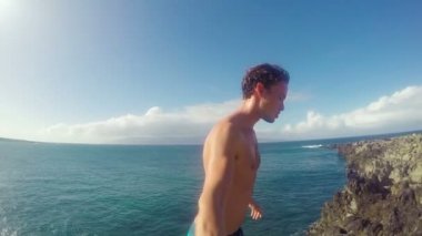 Pov ağır çekim Cliff Backflip atlama. Okyanus içine uçurumdan atlamak atletik genç adam.