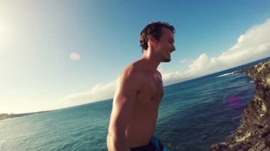 Pov ağır çekim Cliff Backflip atlama. Okyanus içine uçurumdan atlamak atletik genç adam.