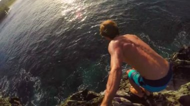 Pov ağır çekim Gopro Selfie sopa Cliff atlama. Okyanus içine uçurumdan atlamak atletik genç adam.